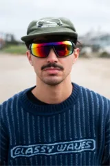 Lentes de sol deportivos con marco negro y cristales espejados con reflejo rojo y amarillo.