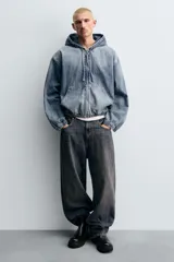 Bota tipo Chelsea de caña media, confeccionada en material sintético liso color negro. Presenta paneles elásticos laterales, tirador trasero y suela track con volumen.