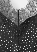 Vestido midi de estilo lencero color negro con estampado de lunares blancos, escote en V con detalle de encaje negro, tirantes finos y diseño entallado.