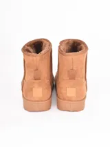 Bota de caña media color negro, con interior forrado en piel sintética y suela de goma antideslizante.