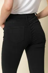 Pantalón jean negro de tiro alto, corte ajustado y cinco bolsillos.