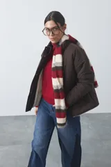 Campera acolchada de nylon color negro, con cuello alto, cierre frontal y botones a presión. Presenta un diseño de rombos y forro interior suave.
