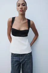 Top de escote cuadrado y tirantes anchos, con diseño bicolor en negro en la parte superior y blanco en el cuerpo, corte ligeramente acampanado y espalda descubierta con lazada.