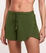 Short de playa tipo salida de baño, color blanco, confeccionado en crepé. Presenta cintura elástica con cordón de ajuste y punteras metálicas, con un diseño de bajo redondeado y corte holgado.