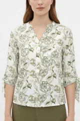Blusa estampada de viscosa con diseño abstracto en tonos beige, negro y marrón, escote en V con cuello mao y mangas tres cuartos con detalles de lazos en los puños.