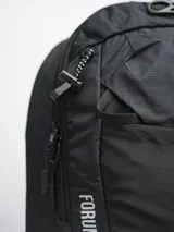 Mochila de trekking color negro, confeccionada en nylon ripstop. Cuenta con compartimento principal amplio, bolsillo frontal abierto, compartimento superior con cierre y pasadores exteriores para accesorios. Incluye tiras ajustables con broche frontal y cubre lluvia integrado.