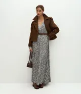 Vestido midi Marfinno en tejido satinado con estampado abstracto, escote en V, mangas largas y falda fluida. Incluye cinturón para marcar la cintura.