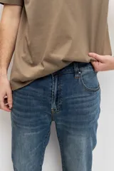Pantalón de jean color azul clásico, de corte regular y diseño recto, con lavado sutil.