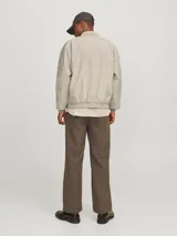 Campera bomber color beige, de manga larga, con cuello baseball y cierre frontal de cremallera.