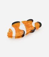 Pinza para el pelo con diseño de pez payaso, elaborada en acetato con acabado marmolado en tonos naranja, blanco y negro.