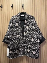 Chaqueta acolchada con estampado ikat en blanco y negro, de corte recto y cuello mao.