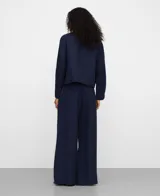 Sobrecamisa corta azul marino, con cuello italiano, manga larga, cierre frontal con botones y bolsillos de plastrón con solapa en el delantero.