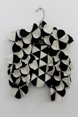 Chaleco negro con apliques circulares de lana merino afieltrada, teñida artesanalmente.