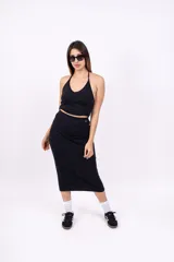 Pollera midi de punto canalé color negro, de corte ajustado.