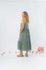 Vestido midi de corte amplio con breteles finos y escote en V. Confeccionado en gasa de algodón con textura, presenta un diseño escalonado con vuelo en el ruedo.