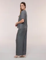 Blusa de calce relajado de lyocell en tono azul denim, con cuello a la base y cierre frontal de botones metálicos. Tiene mangas cortas abullonadas con puños elásticos.