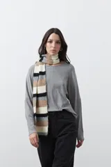 Bufanda de tejido de punto con diseño de rayas horizontales en tonos beige, blanco, gris y negro.