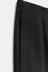 Pantalón negro de tiro alto con bolsillos delanteros y cierre frontal con cremallera y gancho metálico.