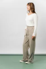 Pantalón deportivo de corte wide leg con caída relajada. Presenta cintura elastizada con cordón ajustable, bolsillos laterales y un interior frizado para mayor abrigo.
