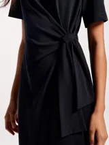 Vestido largo negro de manga corta, con cuello redondo y detalle de nudo o lazo ajustable en la cintura.