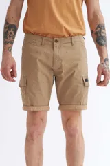 Bermuda cargo color beige con pequeños lunares verdes, bolsillos laterales con solapa y ruedo con dobladillo.