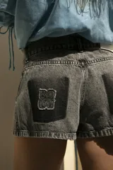 Short de jean gris oscuro con efecto degradé simulando los bolsillos y parche negro con logo bordado en el bolsillo trasero.