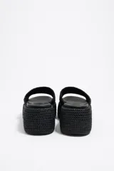 Sandalias negras de rafia tejida con plataforma y logo bordado en dorado.