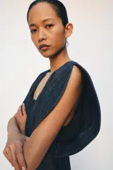 Blusa de Zara confeccionada en mezcla de algodón con acabado denim. Presenta escote redondo, mangas cortas abullonadas con volumen y costuras con pespuntes a contraste. Cierre posterior con cremallera oculta.