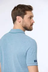 Remera polo lisa de piqué en color celeste, con cuello camisero, cierre frontal con botones y manga corta.
