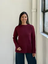 Sweater de punto color bordó, con cuello redondo, mangas largas y dos bolsillos frontales tipo parche.