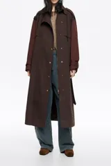 Gabardina de largo medio en color marrón chocolate, con cierre frontal de botones a presión, cuello camisero, mangas largas con puños ajustables, trabillas en hombros y cinturón integrado.