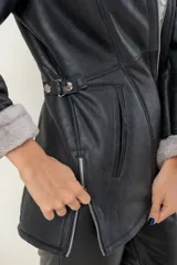 Campera de babylamb color beige con interior de piel sintética al tono. Presenta cierre frontal, capucha desmontable, bolsillos laterales, presillas ajustables en la cintura y cierres en los laterales del ruedo.