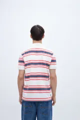 Chomba teñida en prenda con estampado a rayas, confeccionada en algodón lavado. Presenta media cartera de botones y bordado en el pecho.