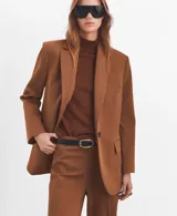Pantalón de vestir marrón, de corte flared, con tiro medio y bolsillos laterales.