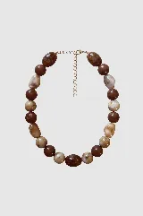 Collar de cuentas de resina con efecto marmolado en tonos marrones y beige, con cadena de extensión metálica dorada.