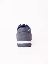Championes urbanos de estilo casual, confeccionados en cuero sintético color azul, con cordones al tono y suela de goma blanca con base gris.