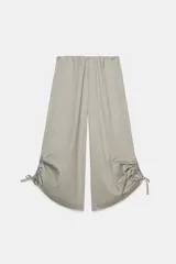 Pantalón culotte de tiro medio con cintura elástica, bolsillos laterales ocultos y bajo con abertura ajustable mediante cordones laterales.