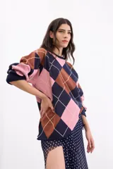 Sweater holgado de tejido de punto con patrón de rombos en tonos azul marino, rosa y marrón, con detalles de líneas en lurex. Presenta cuello redondo y mangas largas.