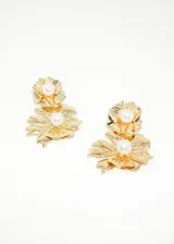 Par de caravanas doradas con forma de flores y perlas sintéticas en el centro.