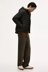 Campera puffer liviana color verde militar, con cuello elevado, capucha y cierre frontal. Incluye bolsillos laterales con cierre y bolsillos interiores abiertos. Diseño guateado y corte ajustado.