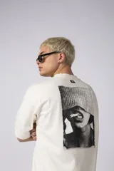 Remera de corte oversize confeccionada en algodón premium de alto gramaje. Presenta un diseño minimalista con un pequeño logo bordado en el centro del pecho y un parche estampado en la espalda. Posee cuello redondo y mangas cortas con caída relajada.