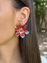 Aros plateados con forma de flor texturizada y doble vuelta de cristales entrelazados.