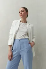 Pantalón negro de corte recto y tiro alto, confeccionado en denim con costuras a contratono en color blanco. Presenta bolsillos frontales tipo parche y cierre frontal con botón y cremallera.