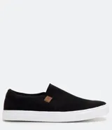 Championes tipo slip on marca Viko, de color negro con suela de goma blanca. Presenta un diseño minimalista sin cordones con paneles elásticos laterales y un pequeño detalle de etiqueta en color marrón.