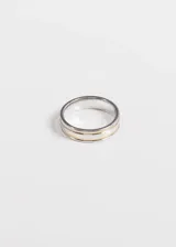 Anillo de acero quirúrgico hipoalergénico plateado con ranuras doradas.