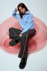 Sweater de punto color celeste con cuello polo y cierre frontal parcial. Presenta detalles de terminación en color rojo en el cuello, puños y ruedo.