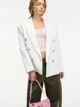 Blazer cruzado blanco de manga larga con solapas y botones frontales.