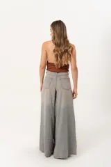 Jean súper campana de tiro alto, color celeste vintage, con pierna extra ancha y caída fluida. Cuenta con bolsillos delanteros y traseros, y cierre frontal con cremallera y botón metálico.