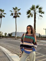 Buzo tejido con diseño de rayas horizontales en tonos marrón, azul, verde y blanco.