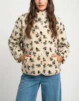 Campera de corderito con estampado floral, cuello alto y cierre frontal con botones a presión. Posee puños elásticos y un diseño de ajuste al cuerpo.